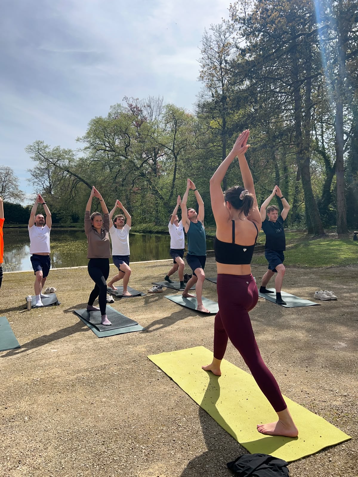 Karin begeleidt een yogagroep in het park